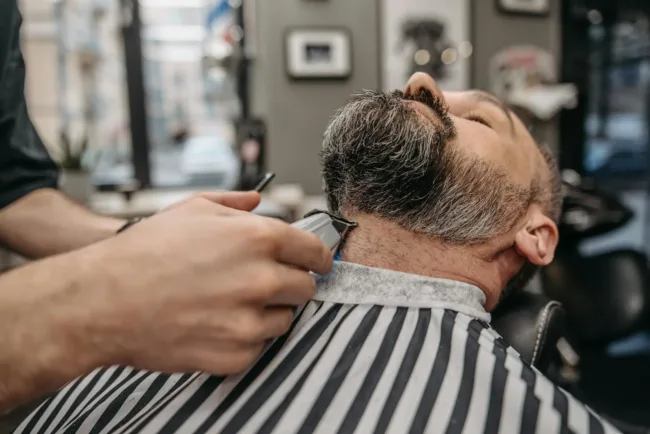 a man having beard trimming